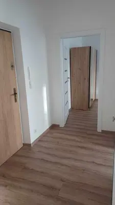 an empty room with a door and a wooden floor at Good Apartament Skawina in Skawina