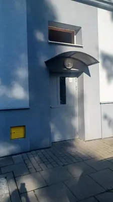 a blue building with a door and a window at Good Apartament Skawina in Skawina