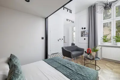 a bedroom with a bed and a chair at Balcony Apartment - Kazimierz- 41 Starowislna Street in Kraków