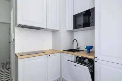 a kitchen with white cabinets and a sink and a microwave at Balcony Apartment - Kazimierz- 41 Starowislna Street in Kraków