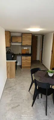 a living room with a table and a kitchen at piąteczka in Niepołomice