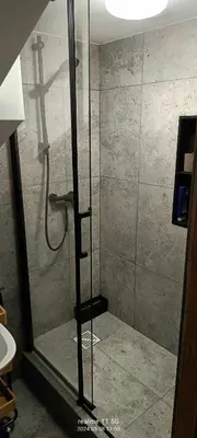 a shower with a glass door in a bathroom at piąteczka in Niepołomice