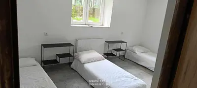 a room with three beds and a window at piąteczka in Niepołomice