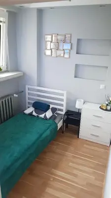 a bedroom with a green bed and a desk at Apartament Olsza in Kraków