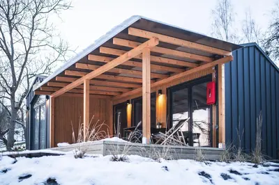 a cabin with a wooden roof in the snow at Domki pod Krakowem - Stare Sady in Kopytówka