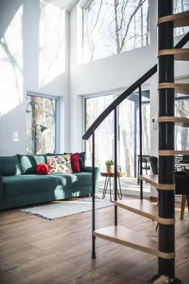 a living room with a green couch and a staircase at Domki pod Krakowem - Stare Sady in Kopytówka