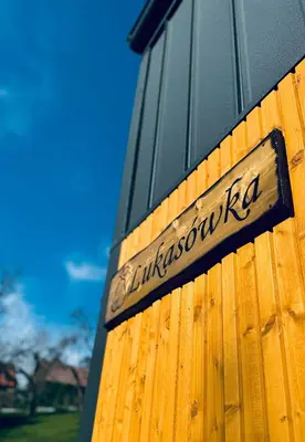 a sign on the side of a wooden building at Domki pod Krakowem - Stare Sady in Kopytówka