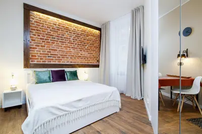 a bedroom with a bed and a brick wall at Apartment for two-Jewish Quarter-Starowiślna 54 in Kraków