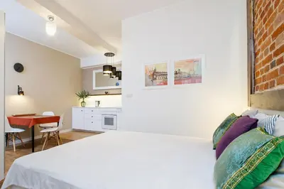 a bedroom with a white bed and a kitchen at Apartment for two-Jewish Quarter-Starowiślna 54 in Kraków