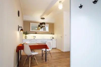 a kitchen and dining room with a wooden table and white chairs at Apartment for two-Jewish Quarter-Starowiślna 54 in Kraków