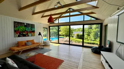a living room with a couch and a large window at Dom w Starym Sadzie z basenem i sauną - Beskid Wyspowy in Nowe Rybie