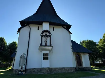 a small white chapel with a black roof at Dom w Starym Sadzie z basenem i sauną - Beskid Wyspowy in Nowe Rybie