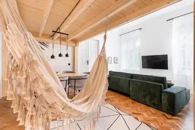 a hammock in a living room with a green couch at Old Town Apartment with Mezzanine by BookingHost in Kraków