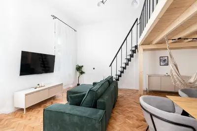 a living room with green furniture and a flat screen tv at Old Town Apartment with Mezzanine by BookingHost in Kraków