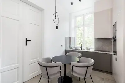 a kitchen with a black table and chairs at Old Town Apartment with Mezzanine by BookingHost in Kraków