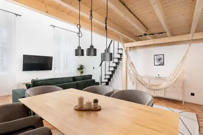 a living room with a wooden table and chairs at Old Town Apartment with Mezzanine by BookingHost in Kraków