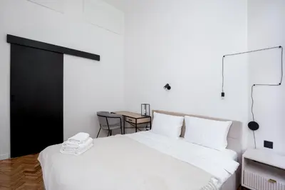 a bedroom with a white bed and a table at Old Town Apartment with Mezzanine by BookingHost in Kraków