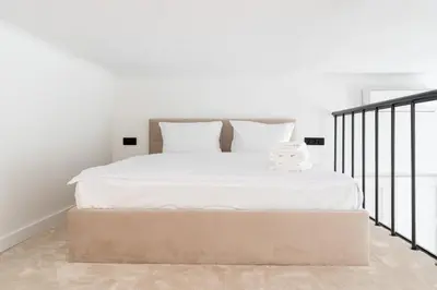 a bedroom with a large bed with white sheets at Old Town Apartment with Mezzanine by BookingHost in Kraków