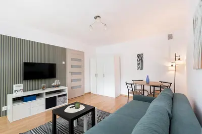a living room with a blue couch and a table at Olsza Comfy Apartment by BookingHost in Kraków