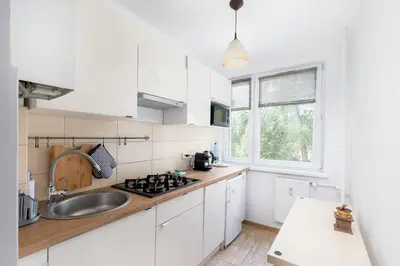 a kitchen with white cabinets and a sink at Olsza Comfy Apartment by BookingHost in Kraków