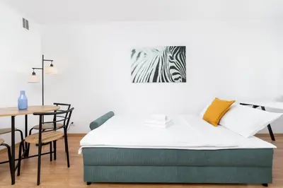 a bedroom with a bed and a table with a zebra picture at Olsza Comfy Apartment by BookingHost in Kraków