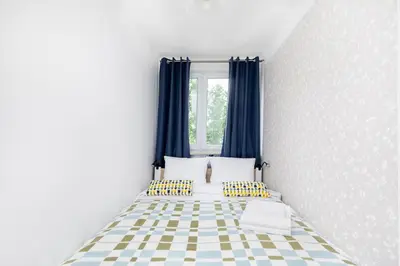 a bedroom with a bed with blue curtains at Olsza Comfy Apartment by BookingHost in Kraków