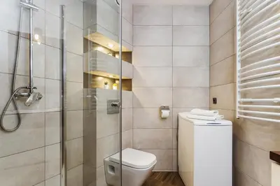a bathroom with a toilet and a glass shower at Studio for two - Starowiślna 54 in Kraków