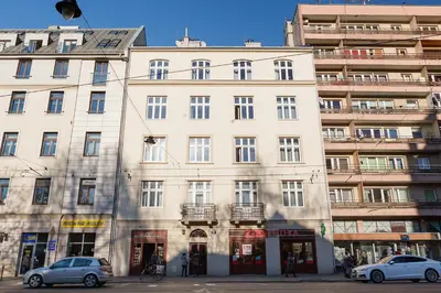 a large white building with cars parked in front of it at Studio for two - Starowiślna 54 in Kraków