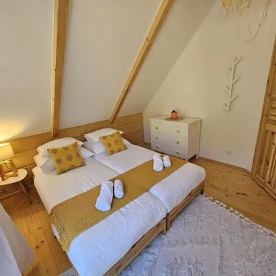 a bedroom with a large white bed with yellow pillows at Casa Viento in Stryszawa