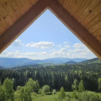 a view of the mountains from a log cabin window at Casa Viento in Stryszawa