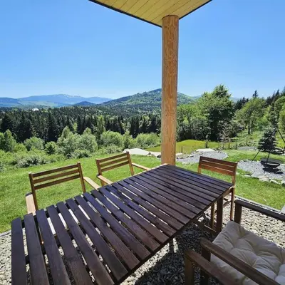 a wooden table and chairs on a patio at Casa Viento in Stryszawa