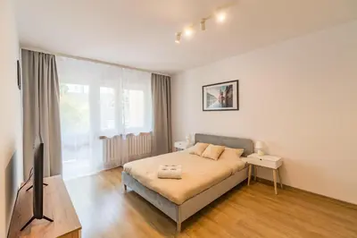 a bedroom with a bed and a flat screen tv at Kraków Czyżyny - Terrace by Rentujemy in Kraków
