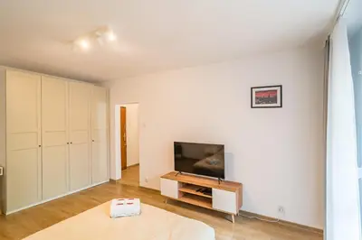 a living room with white walls and a tv at Kraków Czyżyny - Terrace by Rentujemy in Kraków