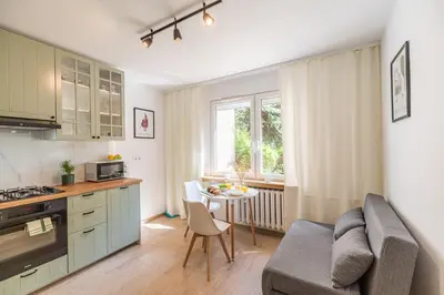 a kitchen and living room with a couch and a table at Kraków Czyżyny - Terrace by Rentujemy in Kraków