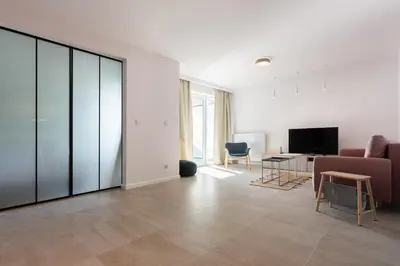 a living room with a couch and a tv at Przestronny apartament Vermelo Parking in Kraków