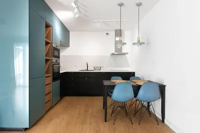 a kitchen with a black table and blue chairs at Przestronny apartament Vermelo Parking in Kraków