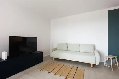 a living room with a white couch and a flat screen tv at Przestronny apartament Vermelo Parking in Kraków