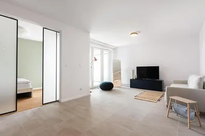 a white living room with a couch and a mirror at Przestronny apartament Vermelo Parking in Kraków
