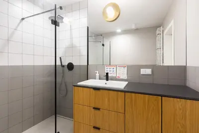 a bathroom with a sink and a shower at Przestronny apartament Vermelo Parking in Kraków