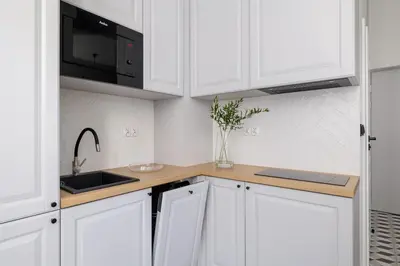 a white kitchen with a sink and a microwave at Kazimierz - Balcony Apartment - 41 Starowislna Street in Kraków