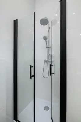 a bathroom with a shower with a glass door at Kazimierz - Balcony Apartment - 41 Starowislna Street in Kraków