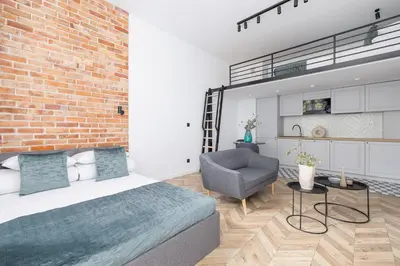a bedroom with a brick wall and a bed and a chair at Apartment with Balcony - 41 Starowislna Street in Kraków