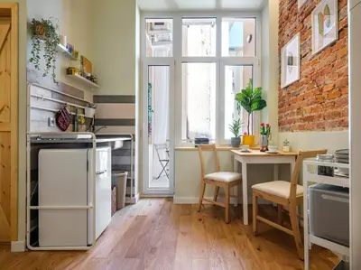 a kitchen with a table and a brick wall at Crocus narrow studio / Kochanowskiego in Kraków
