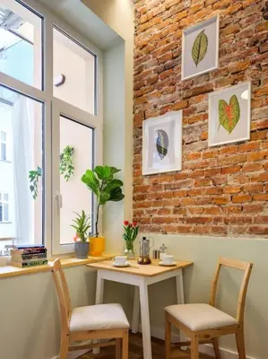 a table and two chairs and a brick wall at Crocus narrow studio / Kochanowskiego in Kraków