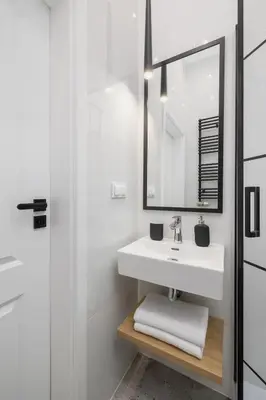 a white bathroom with a sink and a mirror at Apartment with Balcony - Starowiślna 41 in Kraków