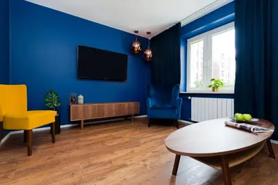 a living room with blue walls and a table at Charming Apartment with balcony, Jewish District in Kraków