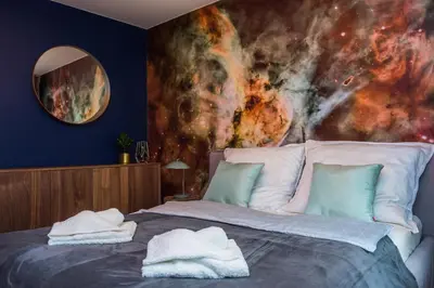 a bedroom with a bed with a painting on the wall at Charming Apartment with balcony, Jewish District in Kraków
