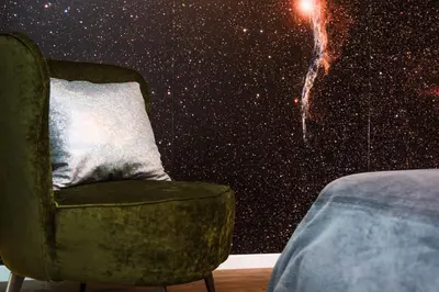 a chair in a room with a galaxy wall at Charming Apartment with balcony, Jewish District in Kraków