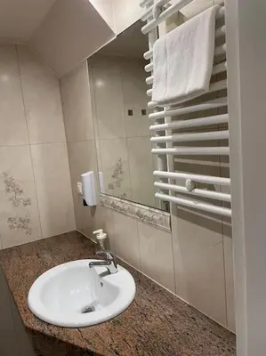 a bathroom with a white sink and a mirror at Househost Apt: Gertrudy 10/43 in Kraków