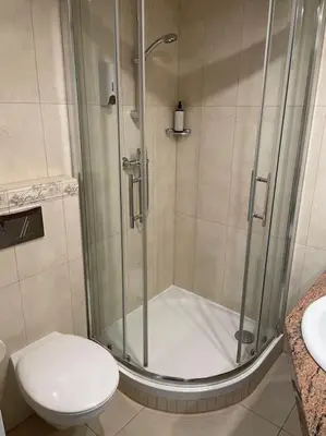 a bathroom with a shower with a toilet and a sink at Househost Apt: Gertrudy 10/43 in Kraków